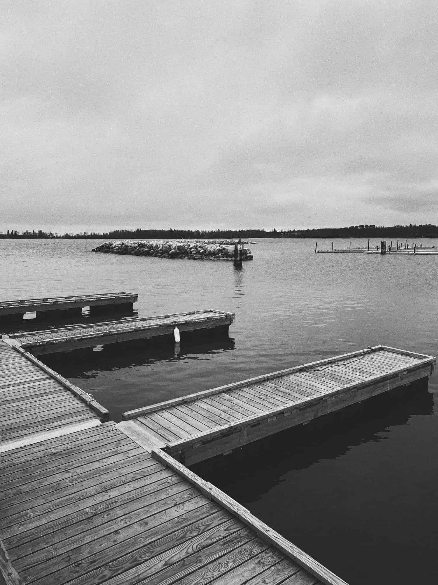 Black and white photograph of a vacant lakeside marina.